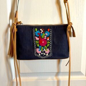 Consuela crossbody. 9”x6”x2”. 2 Blk cloth embroidery and purple snake print.